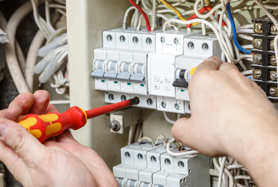 Professionnel électricien travaillant sur l'installation et la vérification d'équipements électriques